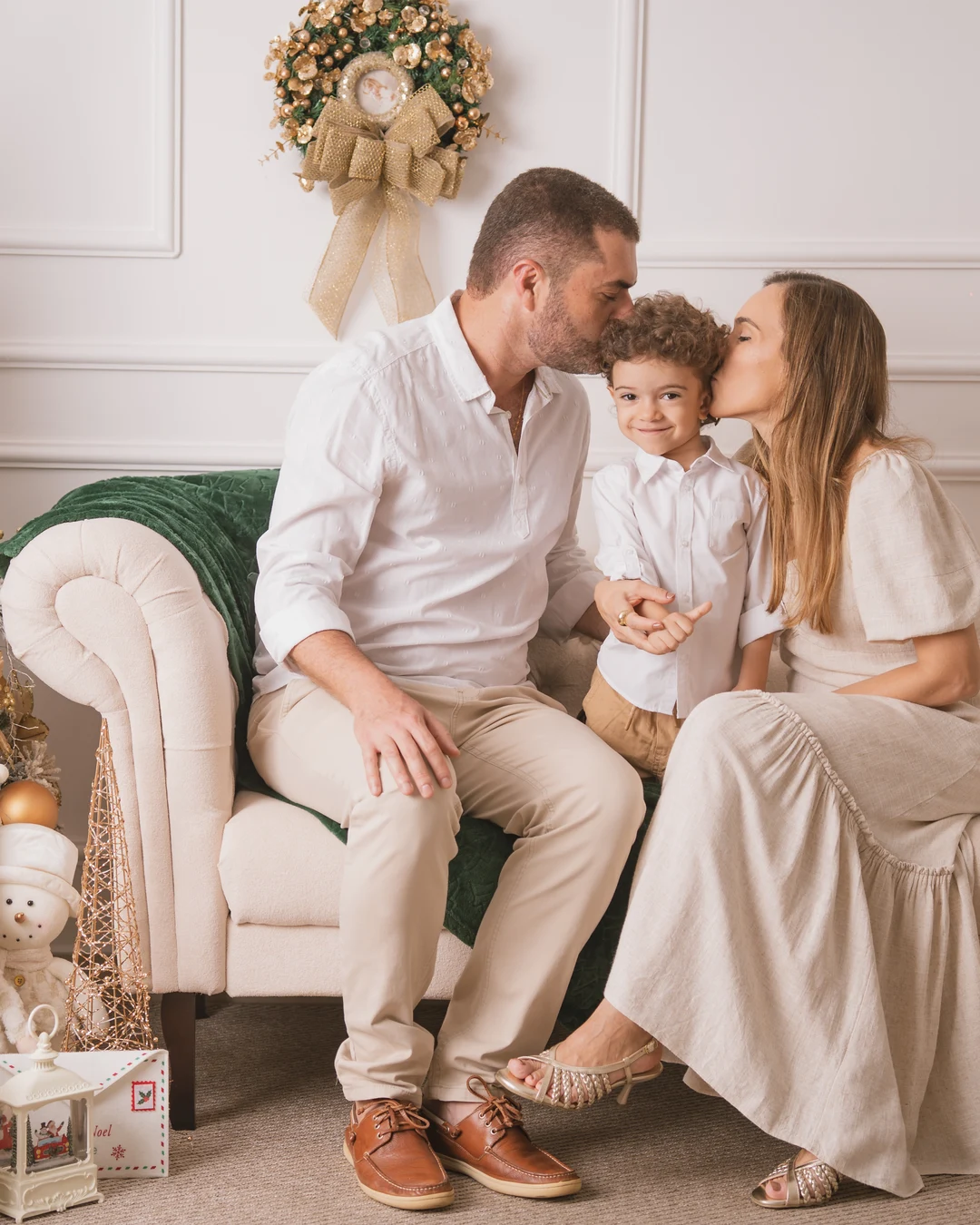 Família reunida no sofá, decoração de Natal dourada
