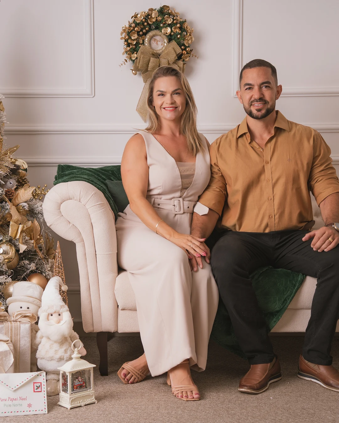 Casal sentado junto, decoração de Natal dourada