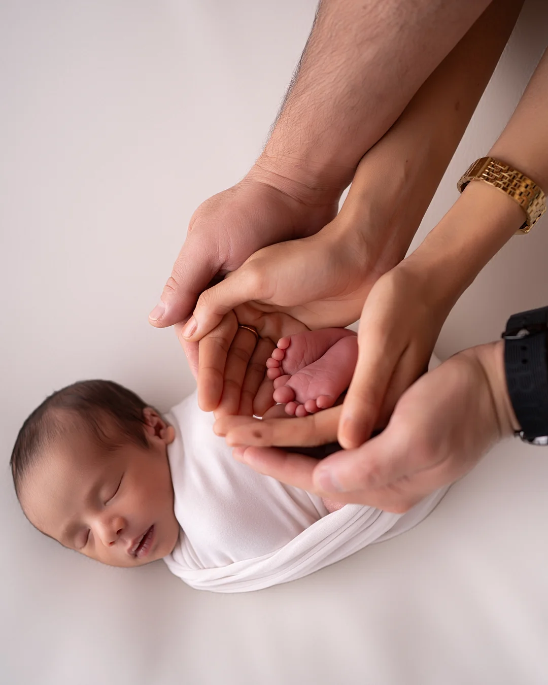 Mãos dos pais segurando os pezinhos do recém-nascido