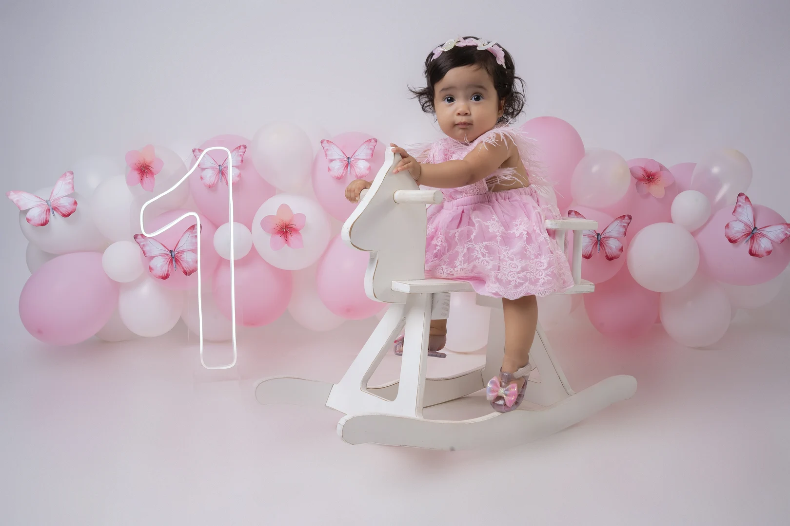 Bebê no cavalinho de balanço, tema borboletas rosa