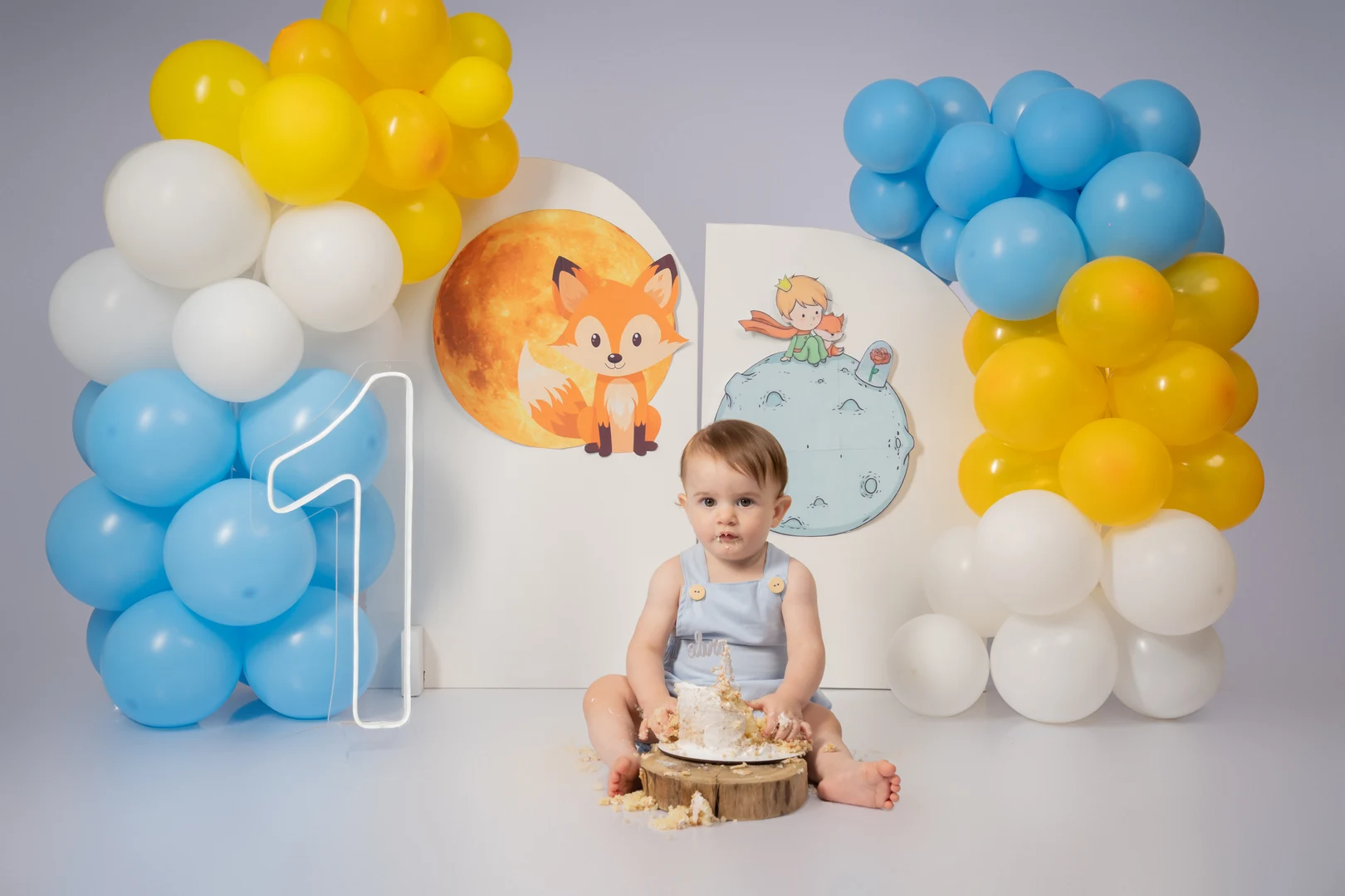 Bebê com as mãos cheias de bolo, tema O Pequeno Príncipe
